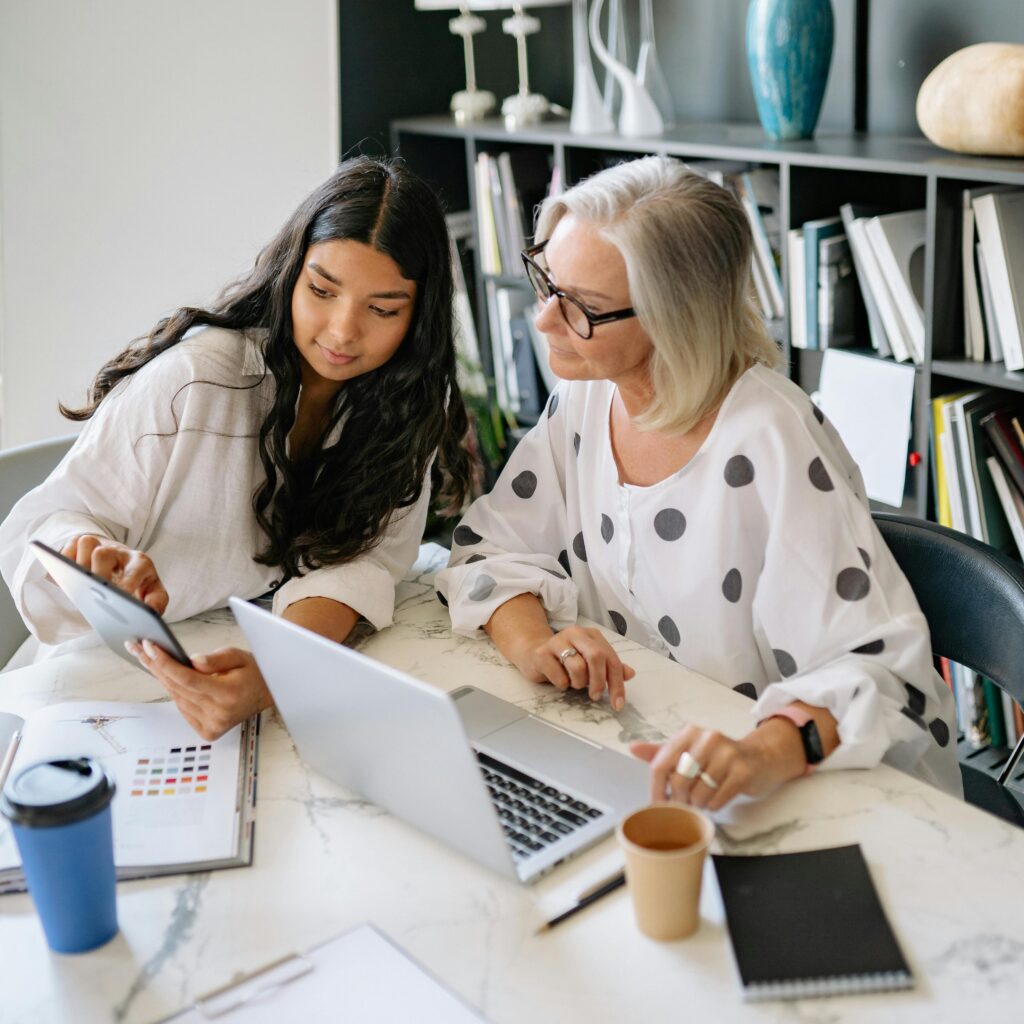 Two professional women discussing branding and web design strategy in a contemporary office.