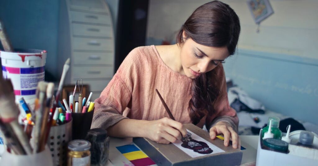 Female artist deeply engaged in painting at her creative studio workspace.